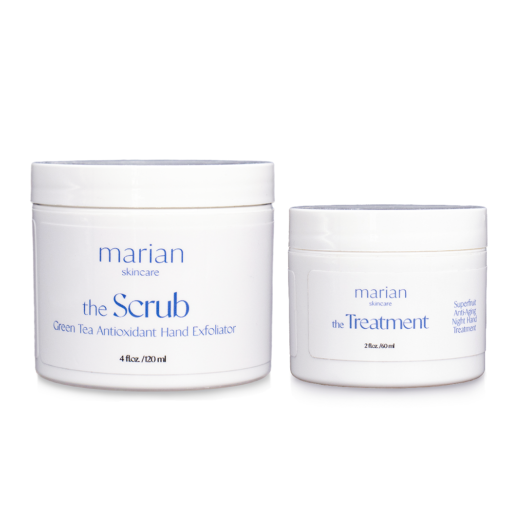 marian skincare the Evening Routine, the Scrub and the Treatment; two white jars sitting side by side, with white labels and periwinkle and black lettering. The jar on the left is slightly larger and reads " marian skincare, the Scrub, Green Tea Antioxidant Hand Exfoliator, 4 fluid ounces, 120 milliliters". The smaller jar on the right reads "marian skincare, the Treatment, Superfruit Anti-Aging Night Hand Treatment, 2 fluid ounces, 60 milliliters". 